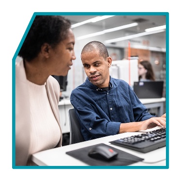 2 people working at a computer.