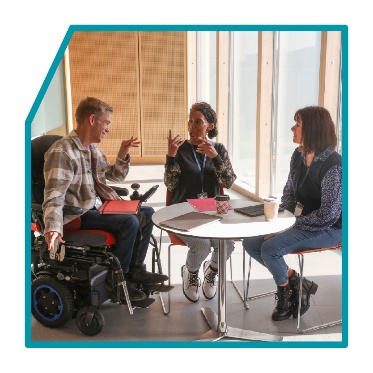 3 people meeting around a table.
